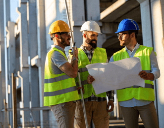 Site workers reviewing the plans of the building