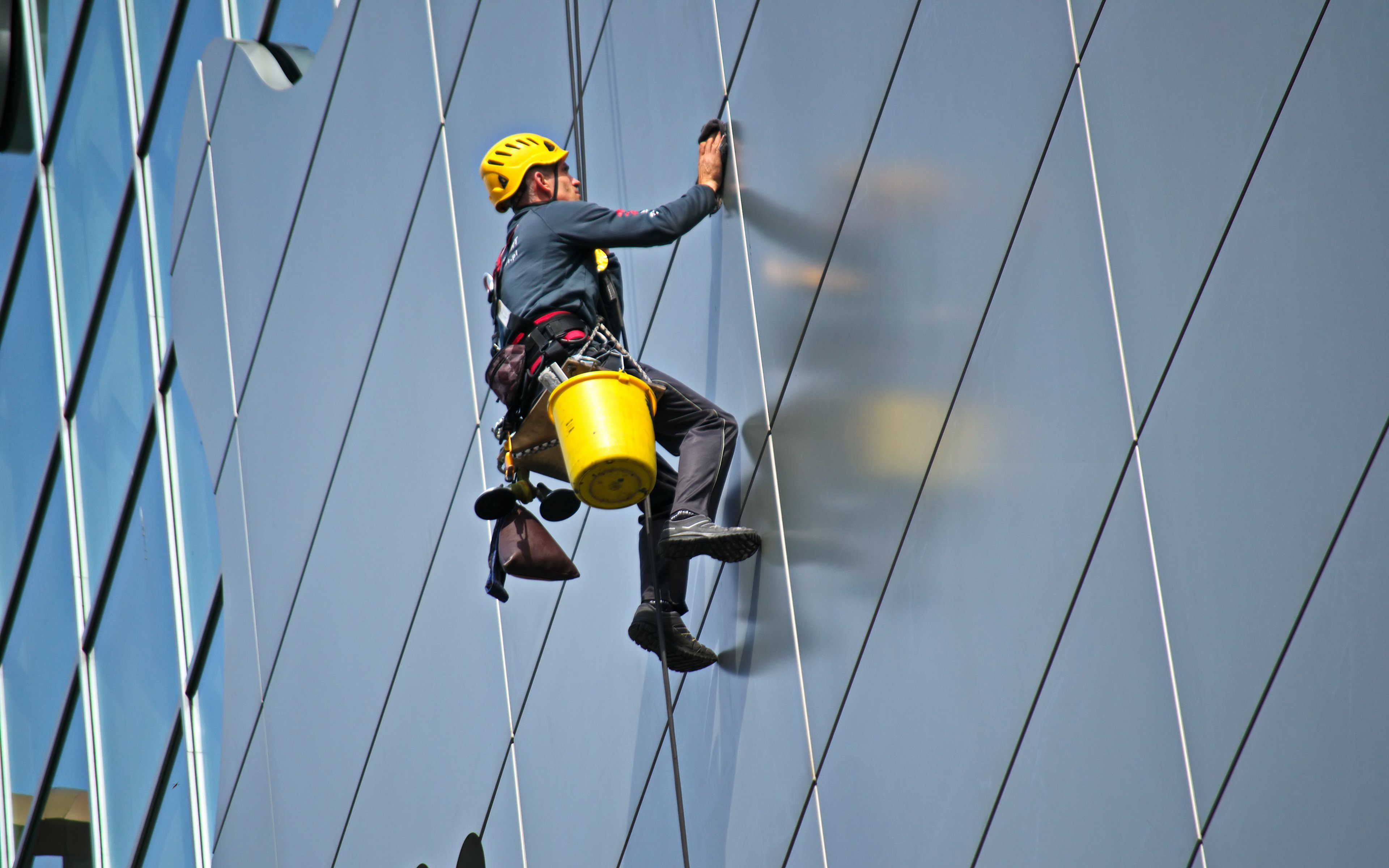 Fall Prevention - Employee cleaning windows on high-rise building